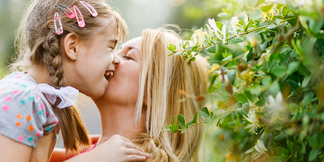 Young girl with a disability is embraced by her mother