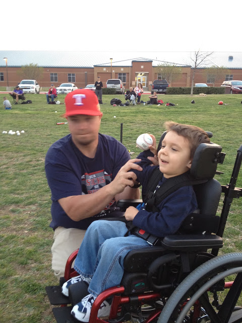 Wade and his dad helping him throw the ball