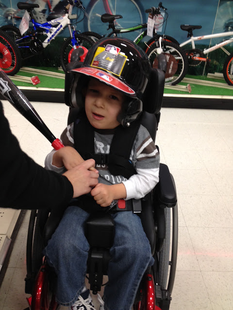 Wade in his wheelchair holding the baseball bat